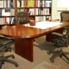 cherry conference table and four gray chairs with white paper on top and cherry wood box