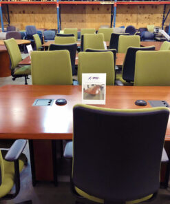 cherry conference table with 8 green chairs and two gray metal plugs