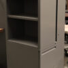 gray storage unit with three shelves and and two cabinets on the right side